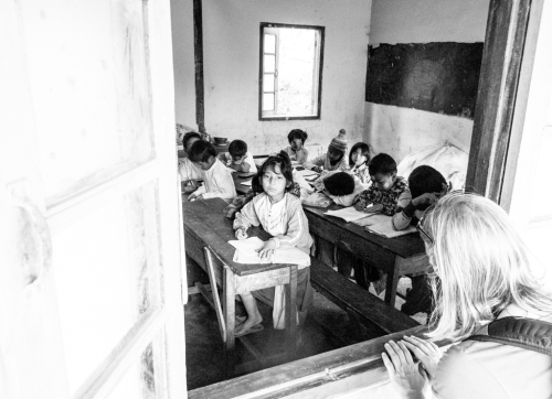 At school the children are taught by rote and copying. In the back of this classroom are several sacks of caustic lime, some of them split, which were being stored there for building works.